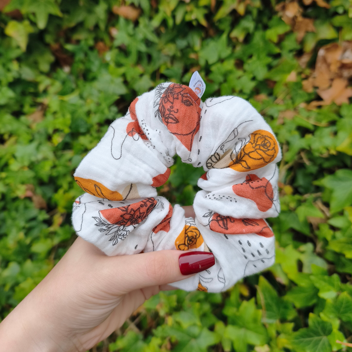 Vrouwelijke, bloemige scrunchie in koper